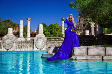 Elegant luxury evening fashion. Glamour, stylish elegant woman in blue long evening gown dress is...
