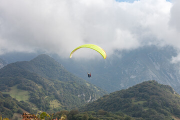 person paragliding over green mountains