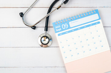 The September 2023 desk calendar and stethoscope medical on wooden background, schedule to check up...