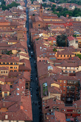 Panoramic view of the red roofs of Bologna. Road cutting through the streets of Bologna
