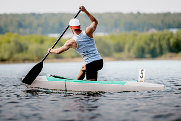 male athlete canoeist on canoe single rowing kayaking race, summer outdoors sports
