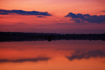 Fototapeta na wymiar Romantic pink skies reflecting on a calm and serene lake
