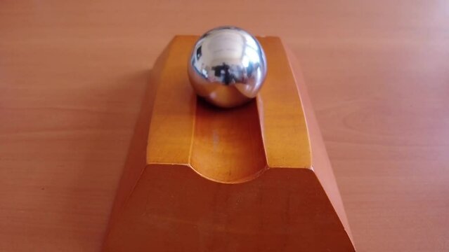 metal ball moving on wooden platform