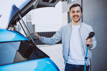 Man holding charger from his electric car