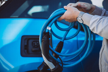Man holding charger from electric car