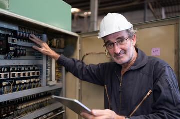 Senior engineer inspects the electrical system and repairs the mechanical system in the machine...