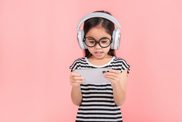 Little girl play phone mobile. Isolated on pink background
