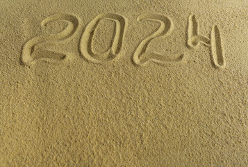 Numbers 2024 on the sea sand. There is space for text.