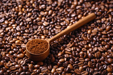 Palone ziarna kawy i drewnianą łyżka z mieloną kawą