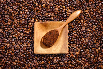 Obraz premium Palone ziarna kawy z drewnianym podstawkiem wypełnionym kawą