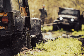 An off-road vehicle pulling another vehicle with a winch. - 602624034