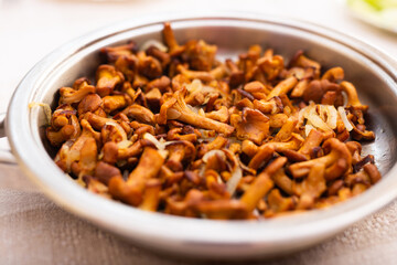 delicious forest mushrooms chanterelles fried in frying pan