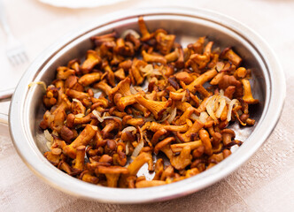 delicious forest mushrooms chanterelles fried in frying pan