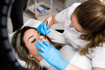 Makeup artist applay permanent makeup procedure. Lips makeup in the cosmetologist's salon.