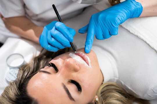 Makeup artist applay permanent makeup procedure. Lips makeup in the cosmetologist's salon.