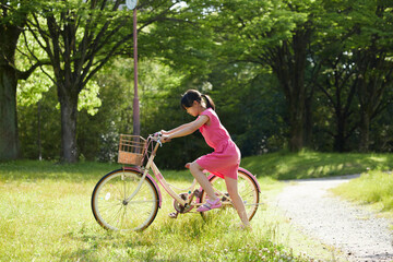 夏の公園で元気で自転車を乗って遊んでいる小学生の女の子の様子