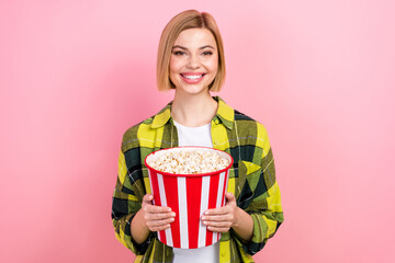 Photo of sweet shiny woman dressed checkered shirt watching movie enjoying pop corn isolated pink color background