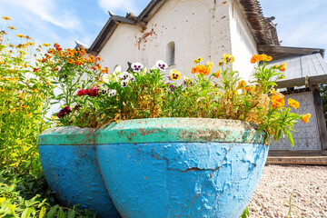 Fototapeta na wymiar Decorative flowers in stone vases against the background of an old church