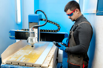 Engineer or technician operating with CNC milling machine in lab. Aircraft capable of GPS surveillance.