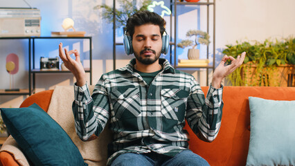 Keep calm down, relax, inner balance. Indian man breathes deeply with mudra gesture, eyes closed,...