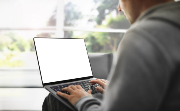 The guy is working on a laptop with a blank screen at home with a view of the park - a template for working from home
