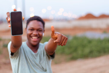  happy african man smiling showing phone display 