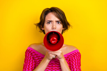 Obraz premium Photo of gloomy serious girl with bob hairstyle dressed off shoulder shirt scream in loudspeaker isolated on yellow color background