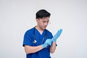 Portrait of a young and skilled medical student, nurse, intern fixing his gloves. Isolated on a...