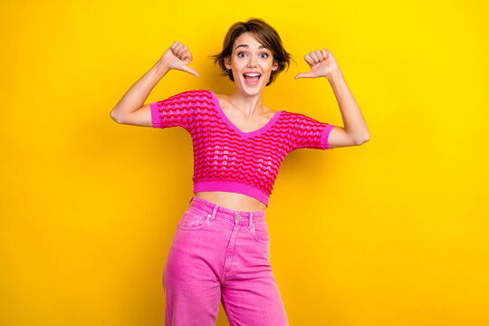 Portrait of good mood ecstatic woman with short haircut wear pink knit top directing at herself isolated on yellow color background