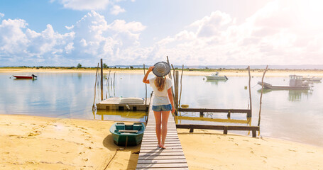 Woman walking on wooden pier,  beautiful beach and fishing boats- Arcachon basin,  France, Basque country - obrazy, fototapety, plakaty