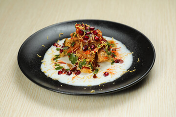 Doi Papri Chaat, papdi, dahi bhalla, bhallay, potato, crackers, masala and yogurt served in plate isolated on background top view of indian spices street food