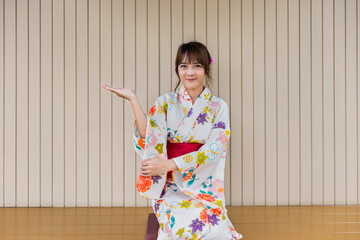 Young woman wearing Japanese traditional kimono in Japanese style house with wooden table.