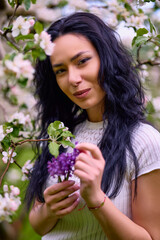 portrait of a beautiful brunette woman in a blossoming apple orchard