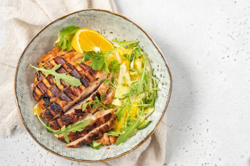 salad with grilled chicken, orange, cucumber and arugula