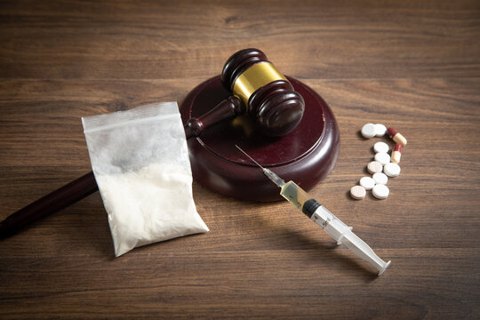 Judge gavel with a syringe, drugs, packet of heroin.