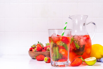 Homemade Strawberry lemonade in jar and glass, with many crushed ice, sliced berries and mint leaves, Frozen strawberry sangria, Iced Tea or mojito drink