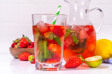 Homemade Strawberry lemonade in jar and glass, with many crushed ice, sliced berries and mint leaves, Frozen strawberry sangria, Iced Tea or mojito drink