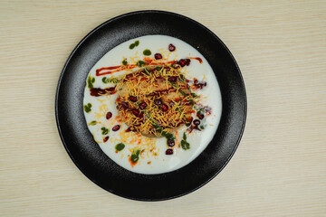 Doi Papri Chaat, papdi, dahi bhalla, bhallay, potato, crackers, masala and yogurt served in plate isolated on background top view of indian spices street food