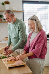 Senior couple cooking together in their kitchen.