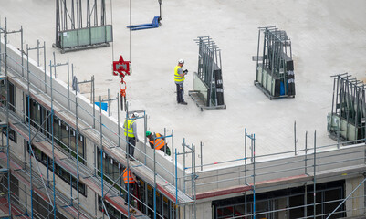 Glazier installing windows on a commercial building.