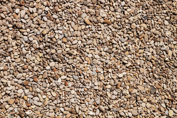 A sidewalk of small stones. Small pebbles teksura.