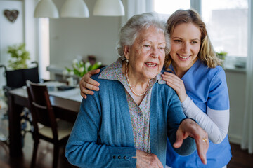 Young nurse hugging her senior woman client.