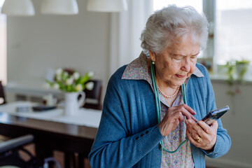 Portrait of happy senior woman with smartphone.