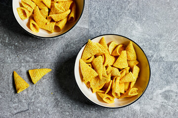 two bowls contains cone corn chips on grunge gray background