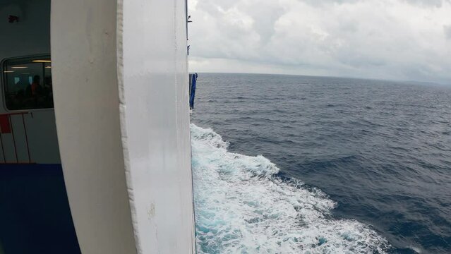 Large boat sail on open sea making water foam and waves, slow motion