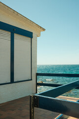 Fototapeta na wymiar Front view of seashore with white house, turquoise ocean water and horizon