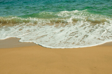 Front view of seashore with sand,  turquoise ocean water and horizon