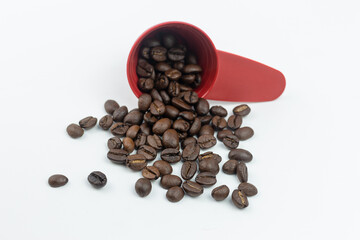 Coffee beans in a red cup isolated on white background.