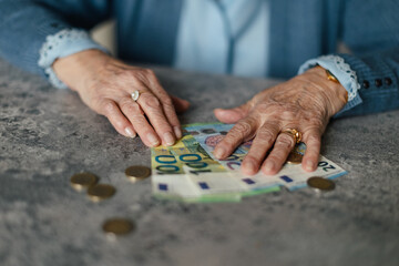 Close up of senior woman counting her money at home. - obrazy, fototapety, plakaty