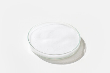White foam in a Petri dish on a light background.
